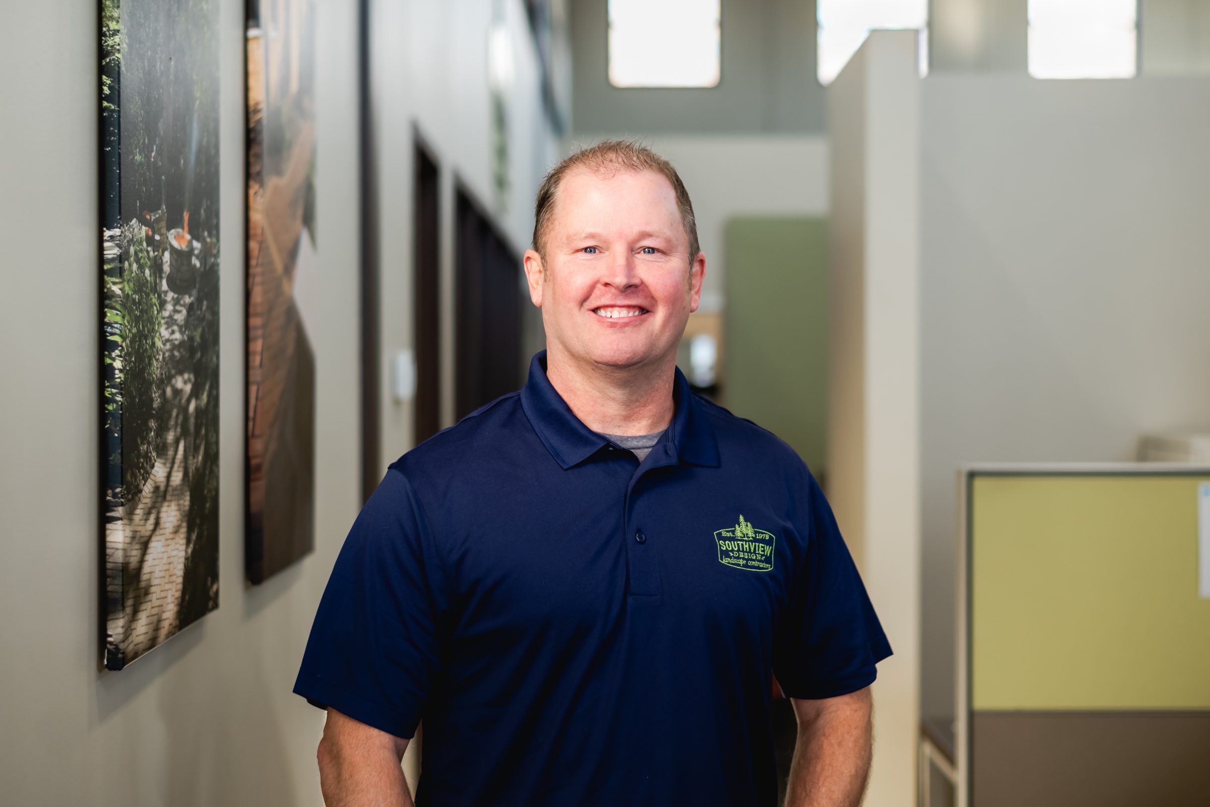Smiling man in blue polo shirt indoors