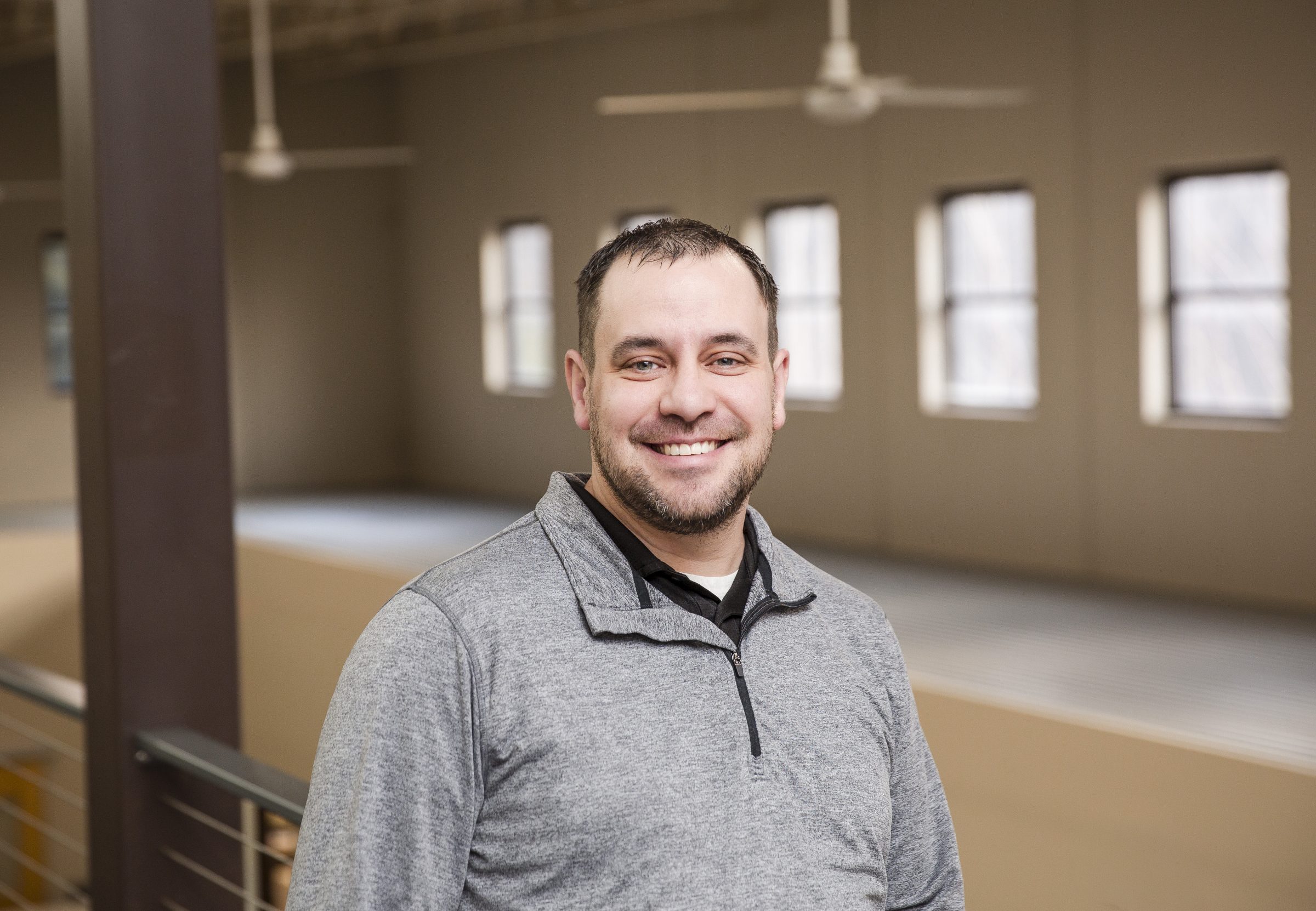 Smiling person in a spacious room.