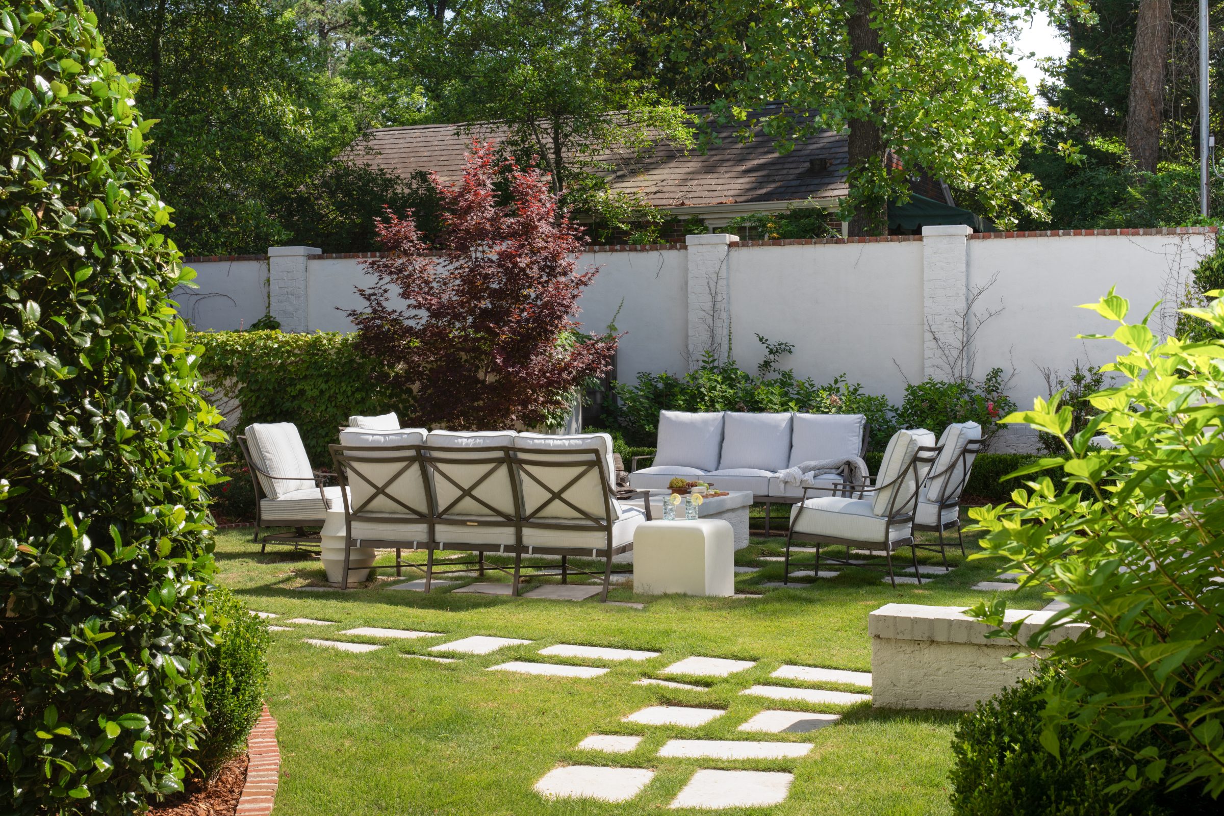Backyard patio with seating and lush greenery.