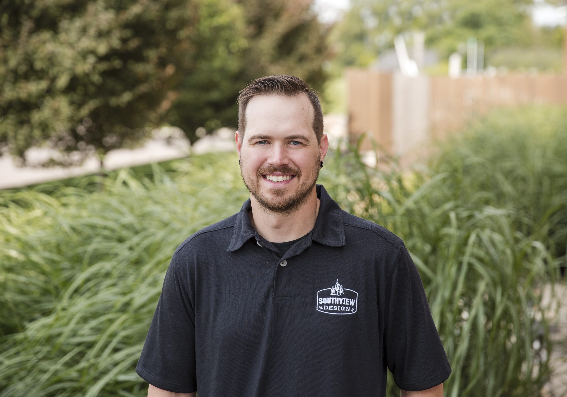 Man smiling outdoors in a black shirt