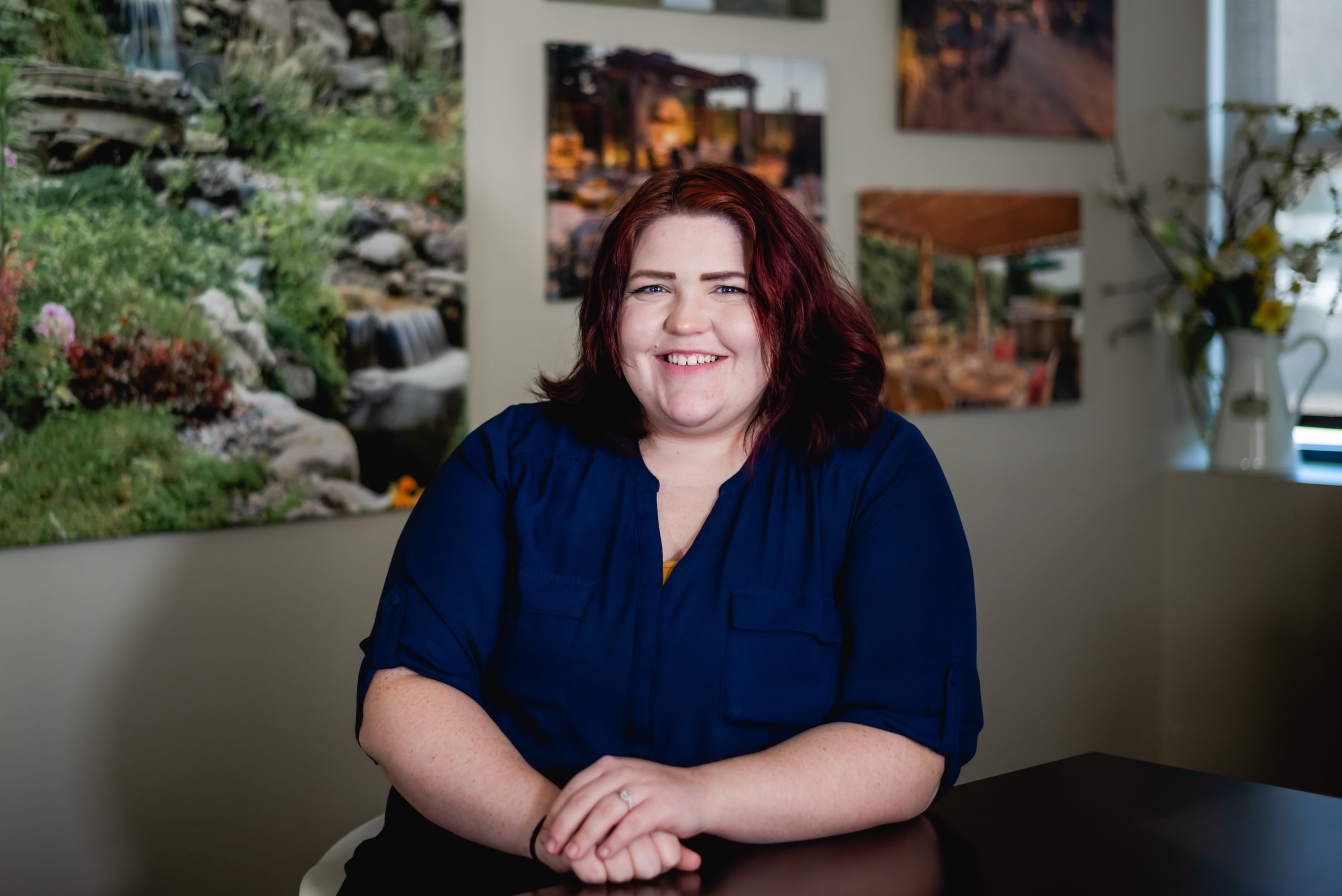 Smiling person in a blue shirt at a table.