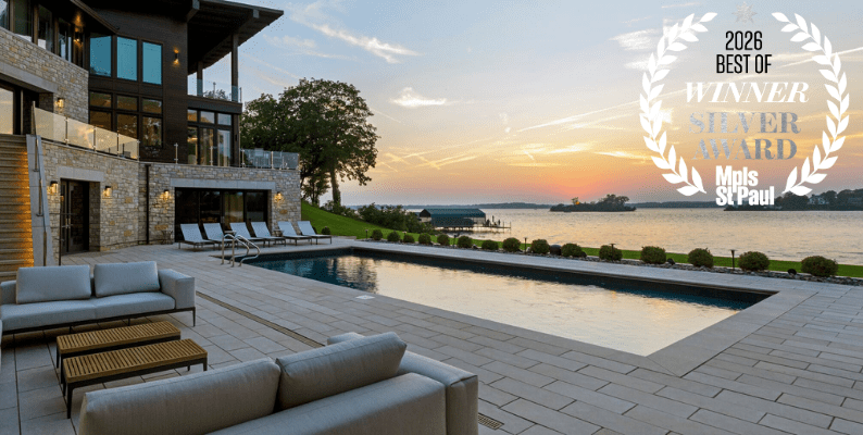 Luxury lakeside home with pool at sunset.
