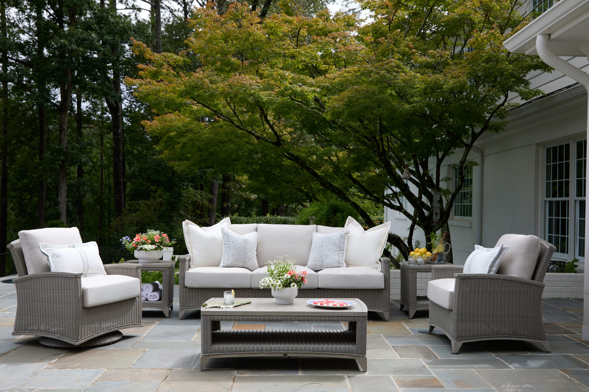 Outdoor patio with wicker furniture and potted plants.