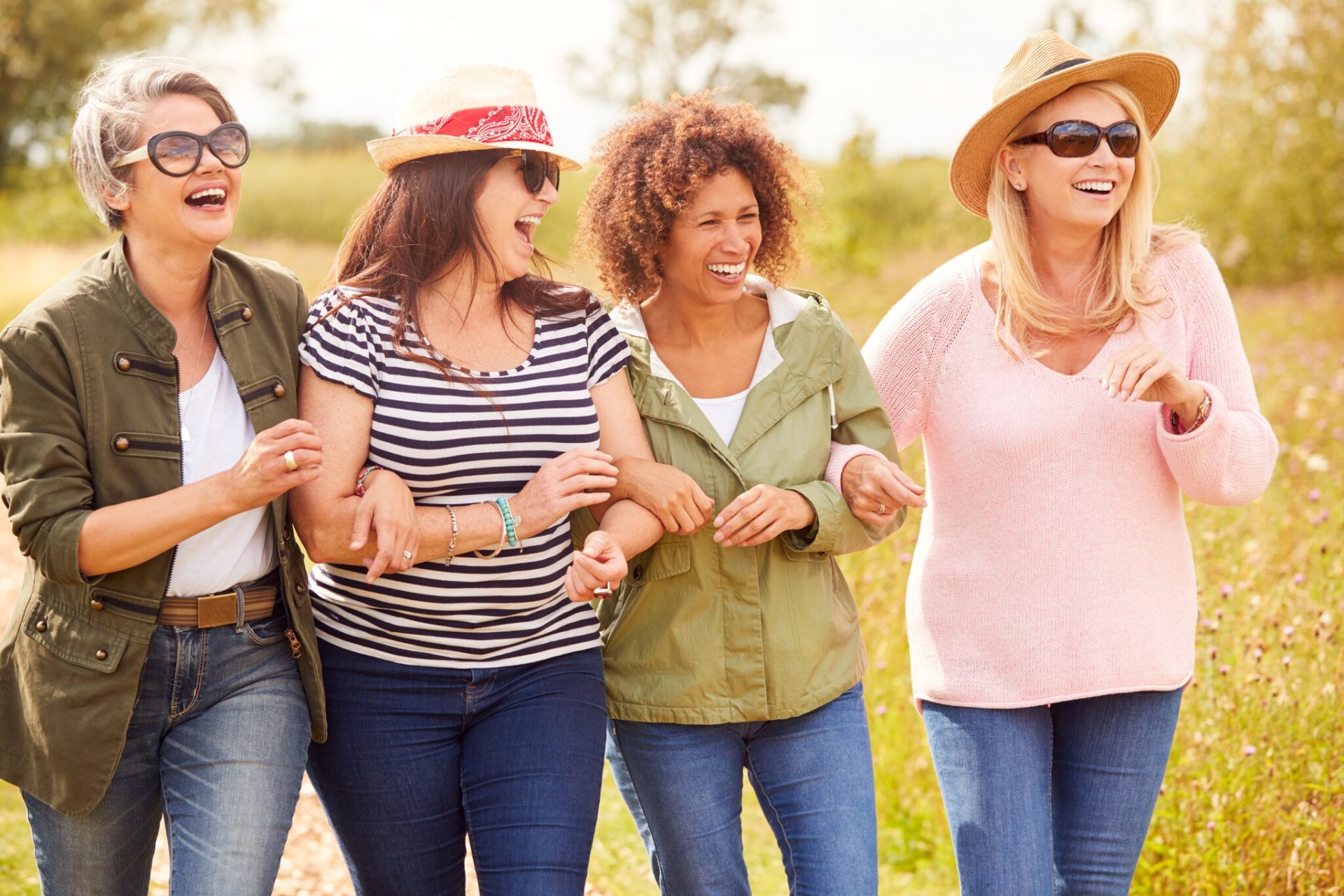 Four women laughing together outdoors