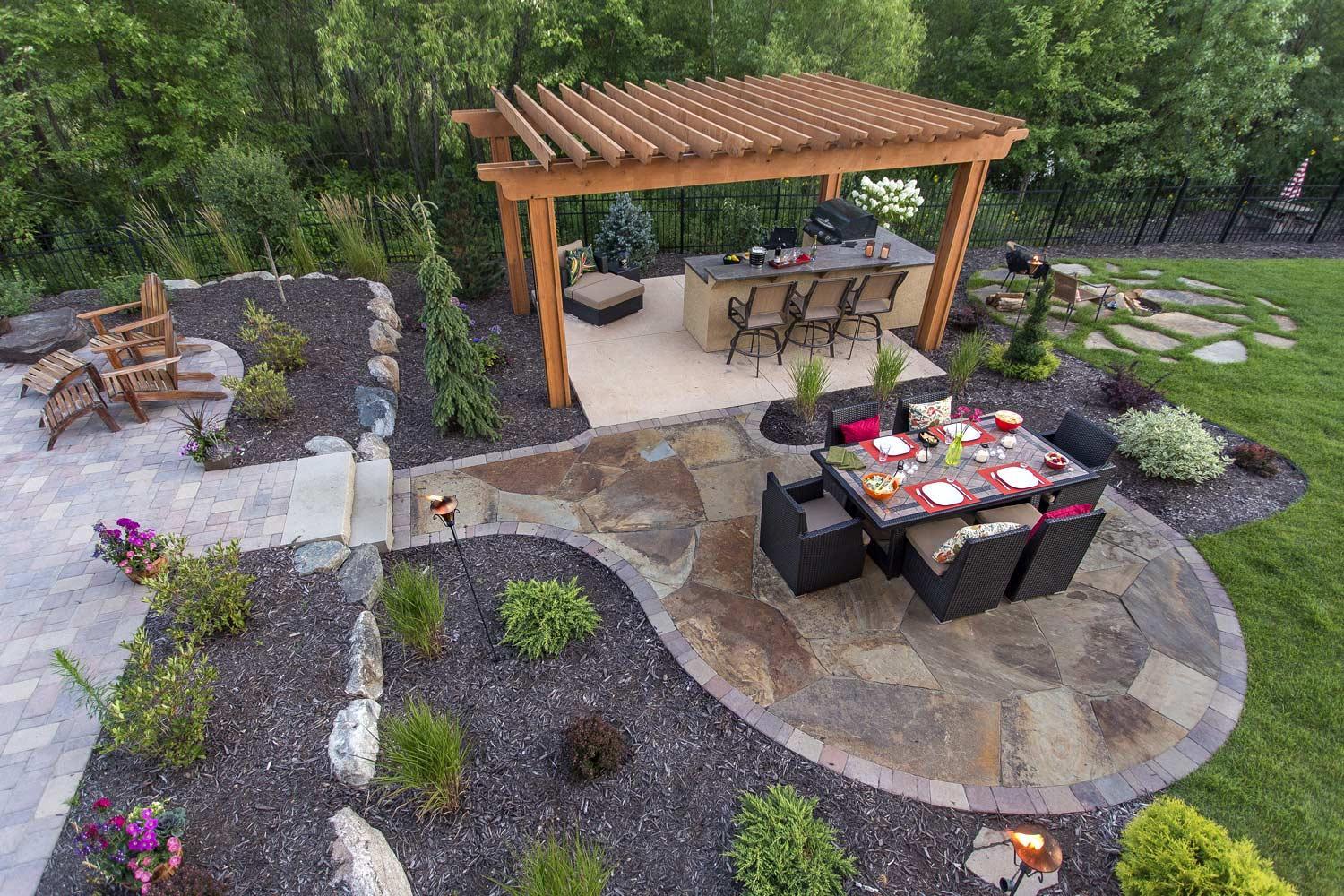 Aerial view of flagstone patio with pergola, outdoor kitchen, and fire pit area