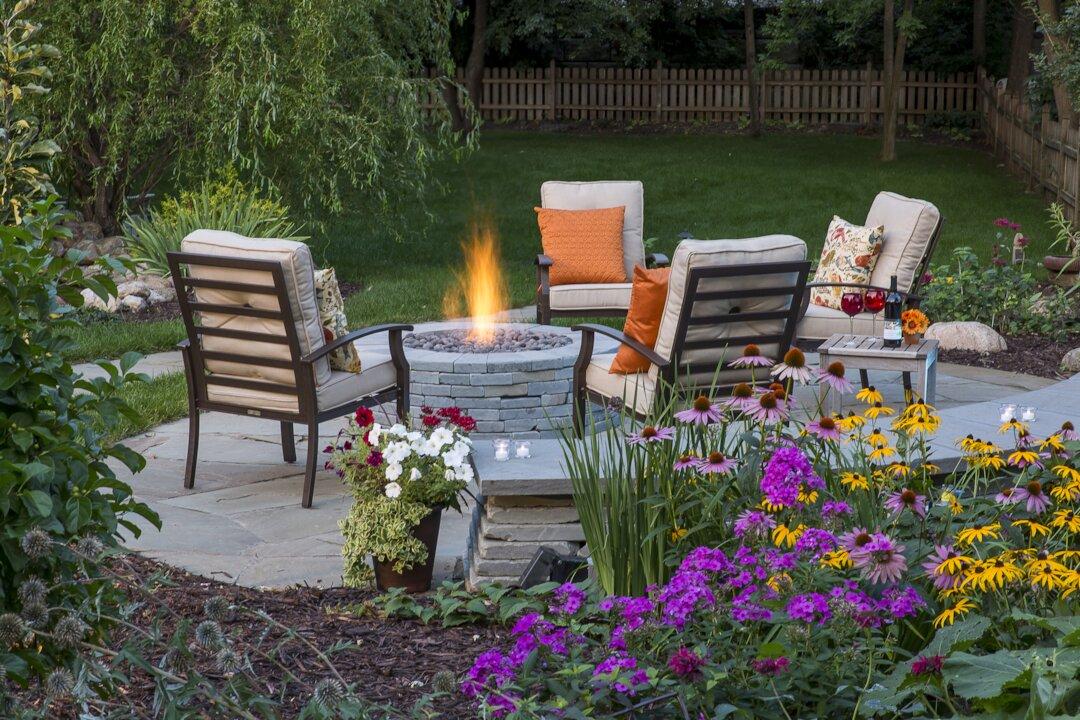 Flagstone patio with stone fire pit surrounded by colorful perennial garden beds