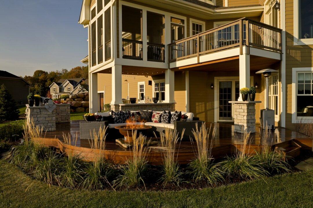 Multi-level wood deck with fire pit seating, ornamental grasses, and covered lower patio