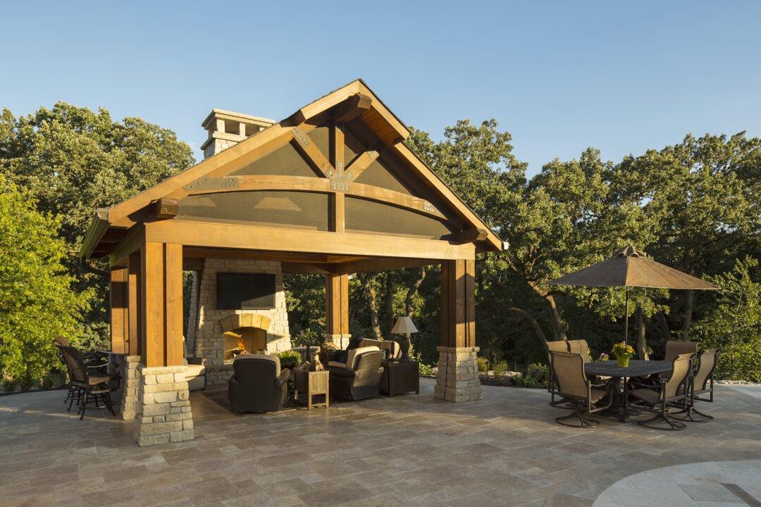 Timber frame pavilion with stone fireplace, outdoor living room, and patio dining area