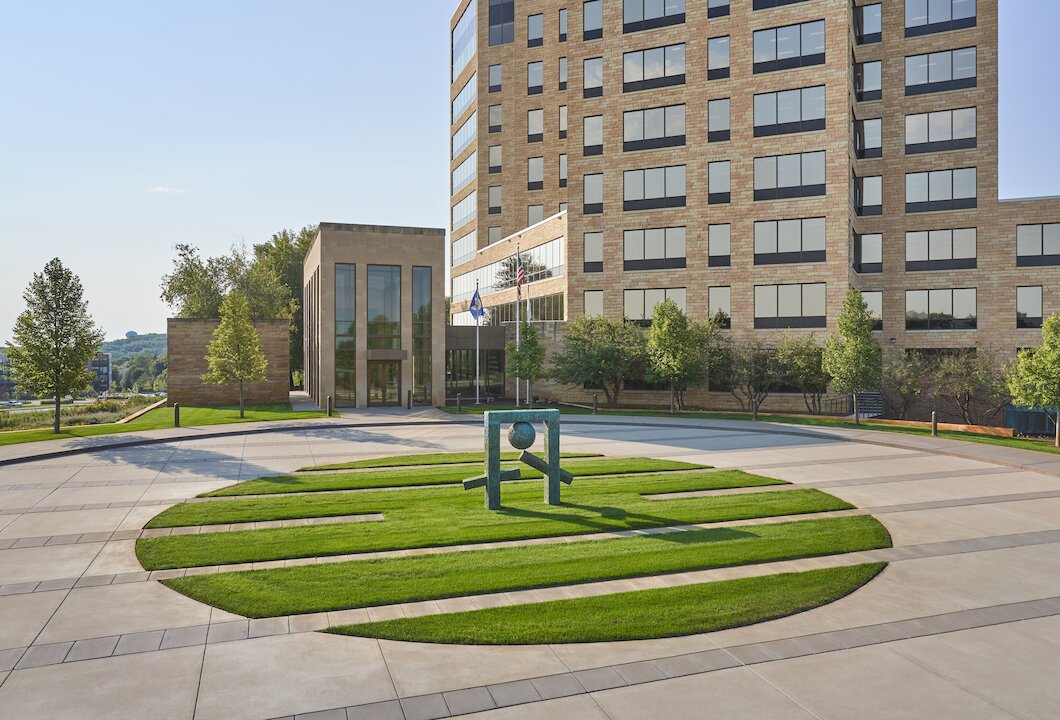 Modern building with sculpture in front courtyard.