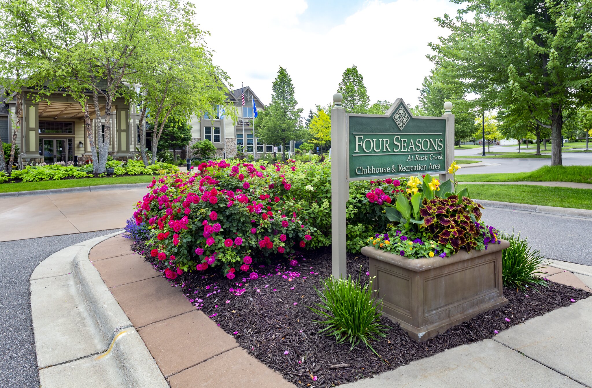 Four Seasons clubhouse entrance with vibrant flowers.