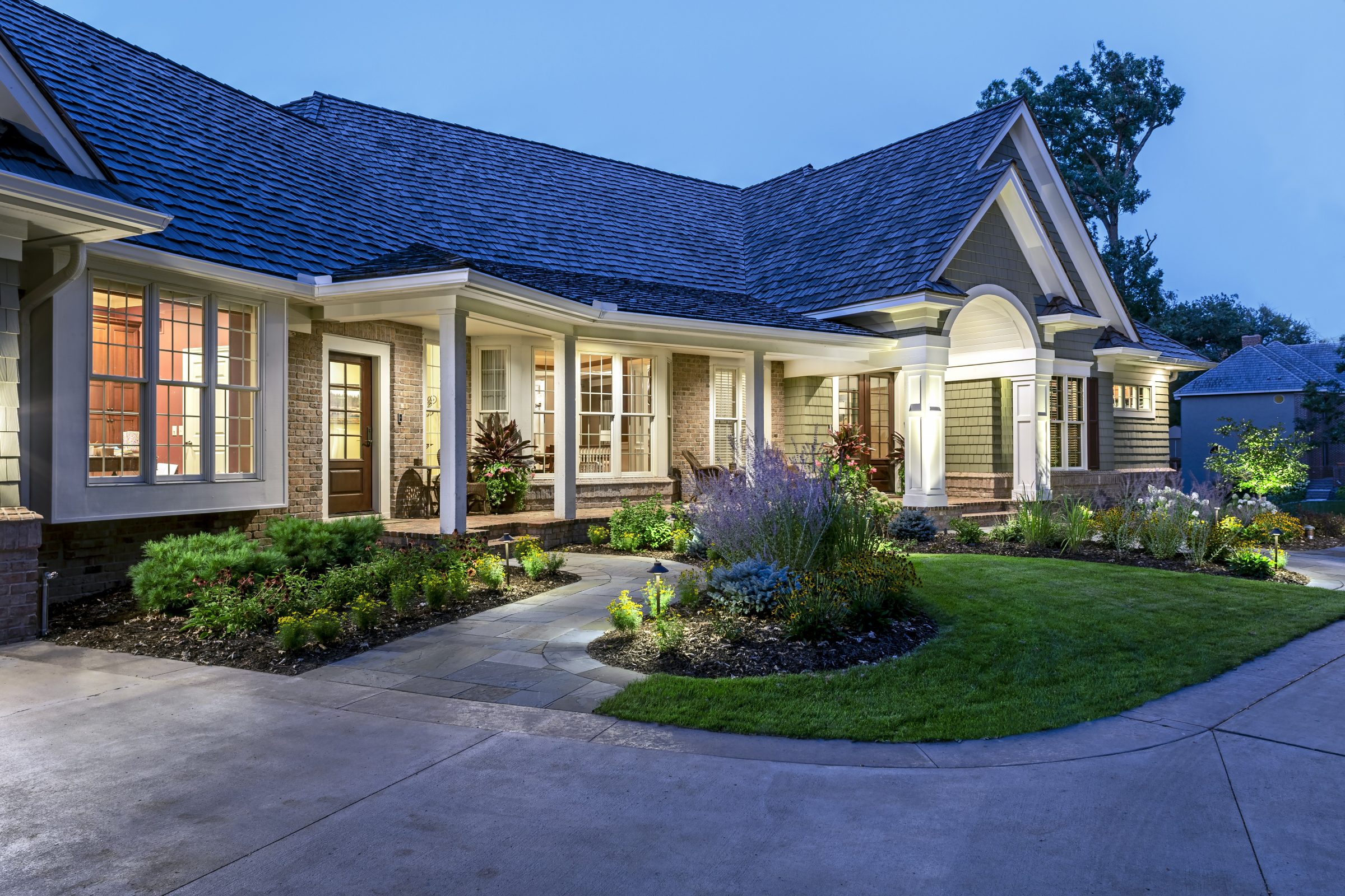 Illuminated suburban house with garden at dusk