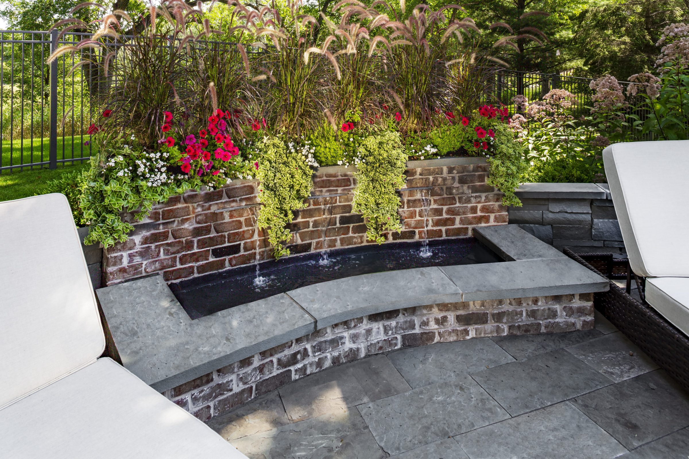 Outdoor patio with water feature and flower garden.
