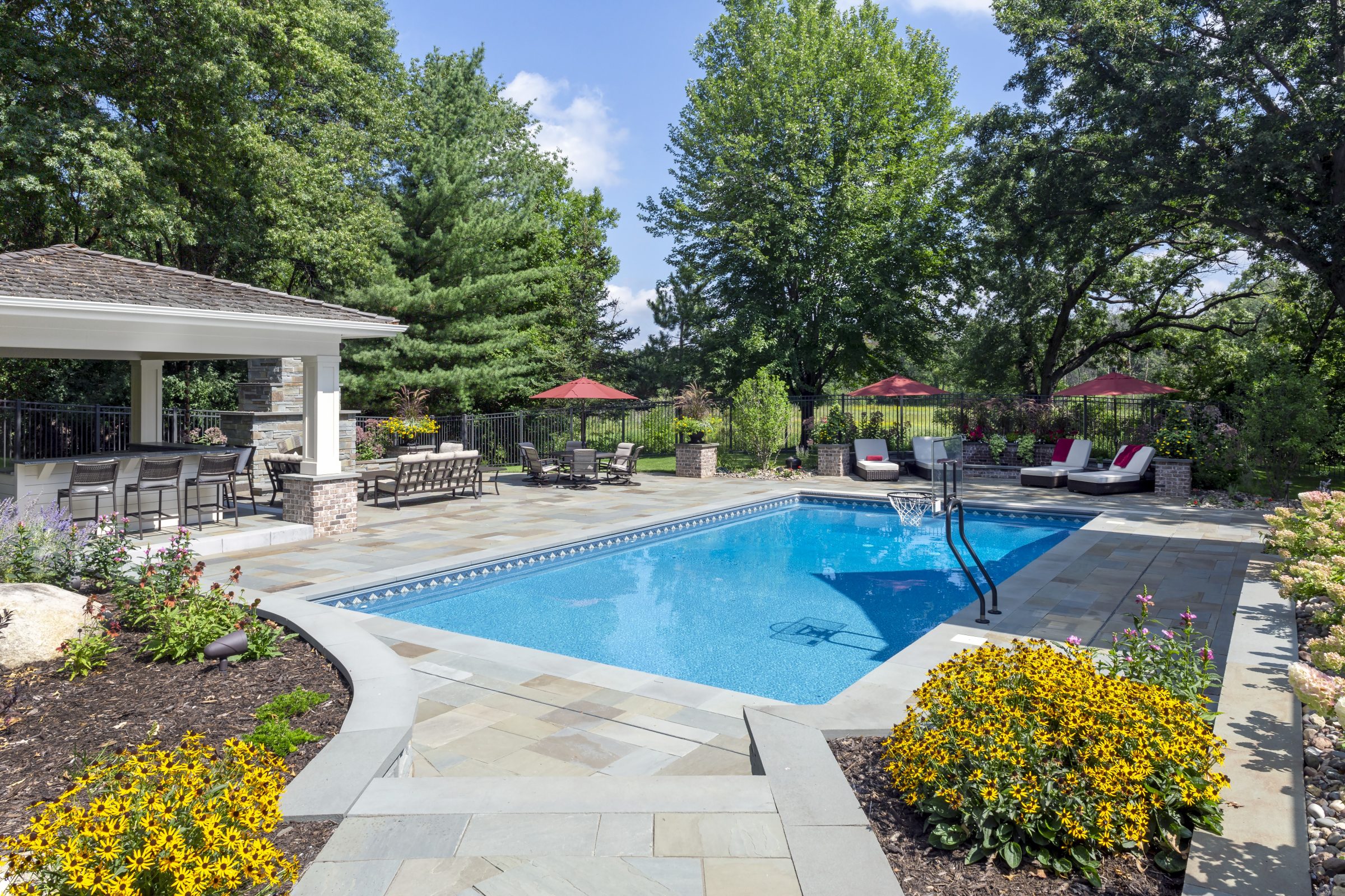 Backyard pool with patio and seating area.