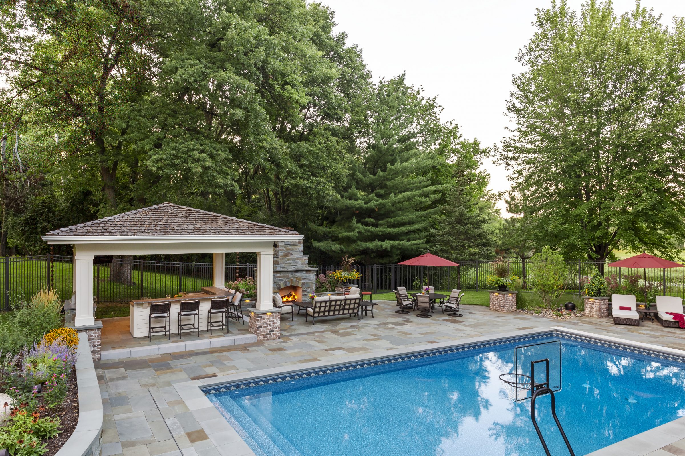 Luxury backyard pool with gazebo and fireplace.