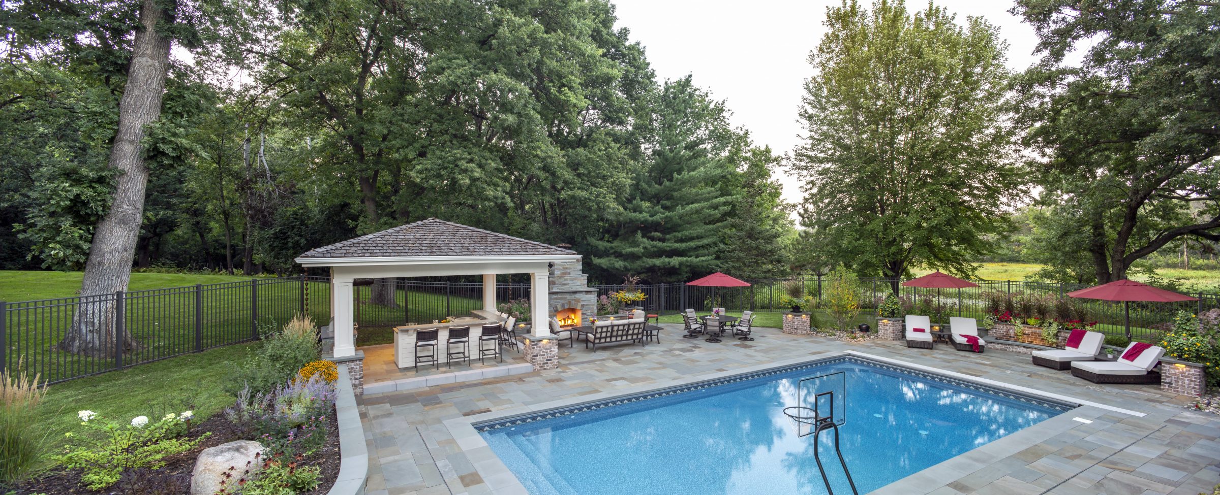 Luxury backyard with pool, patio, and pool house.