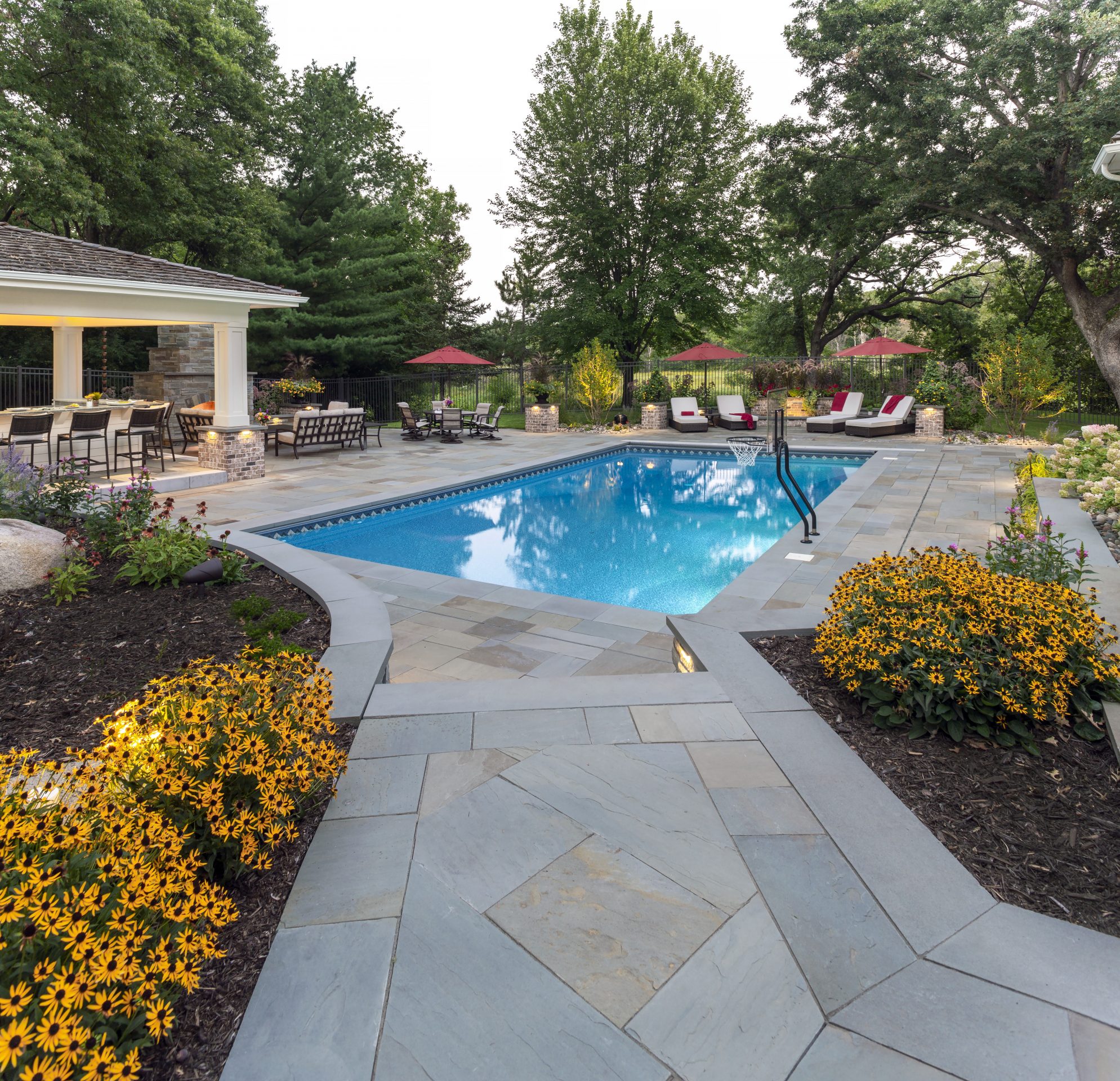 Luxury backyard with pool and sun loungers.