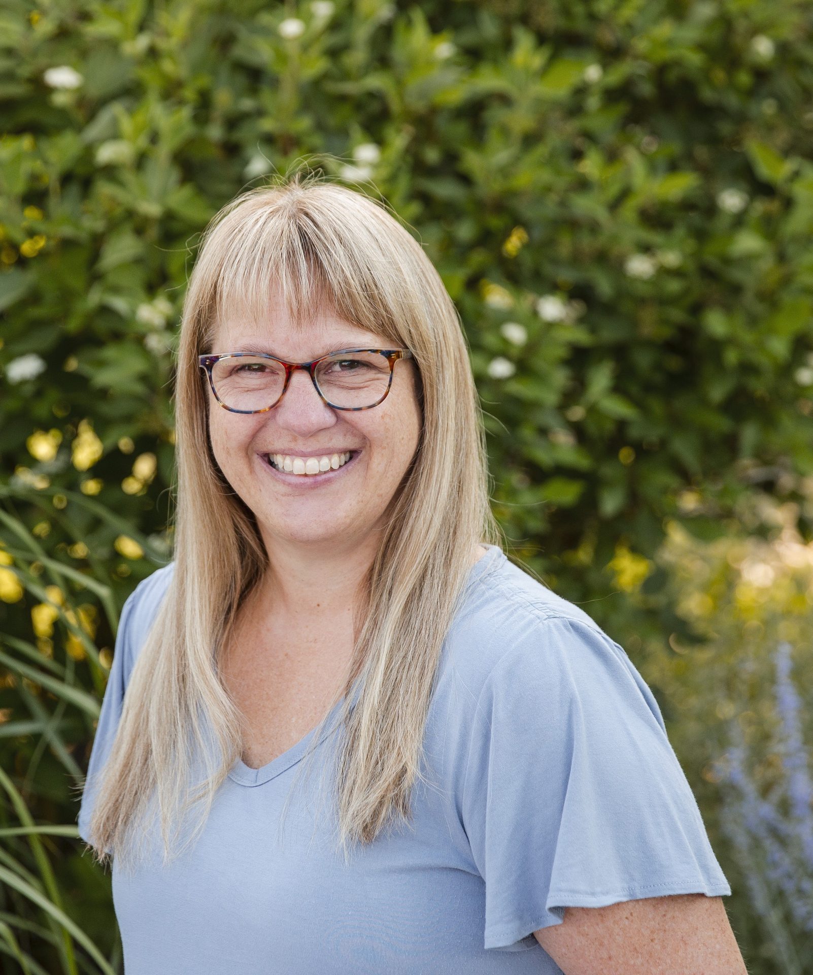Smiling person in garden background.