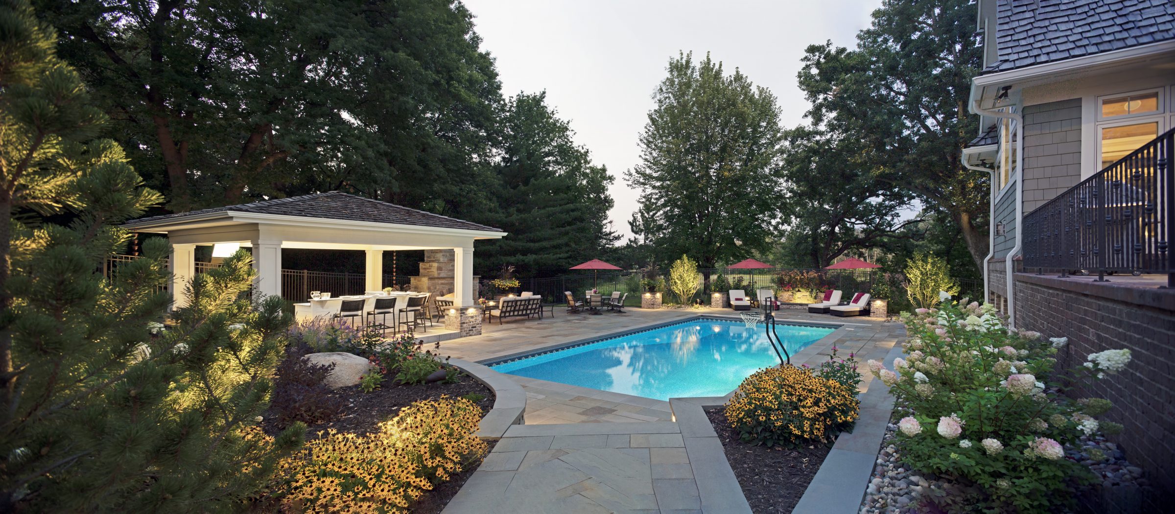Luxurious backyard pool with gazebo and lounge chairs.