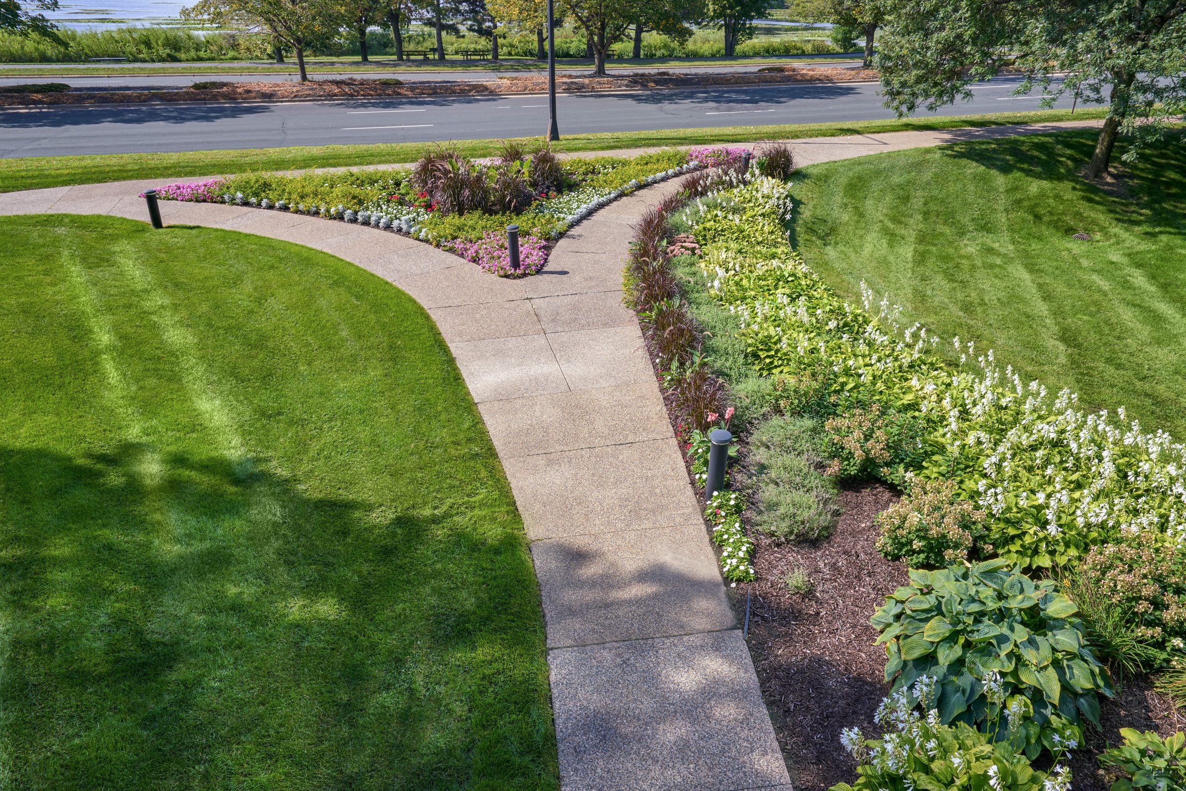 Curved walking path through landscaped lawn and planting beds at Normandale Lakes Office Park