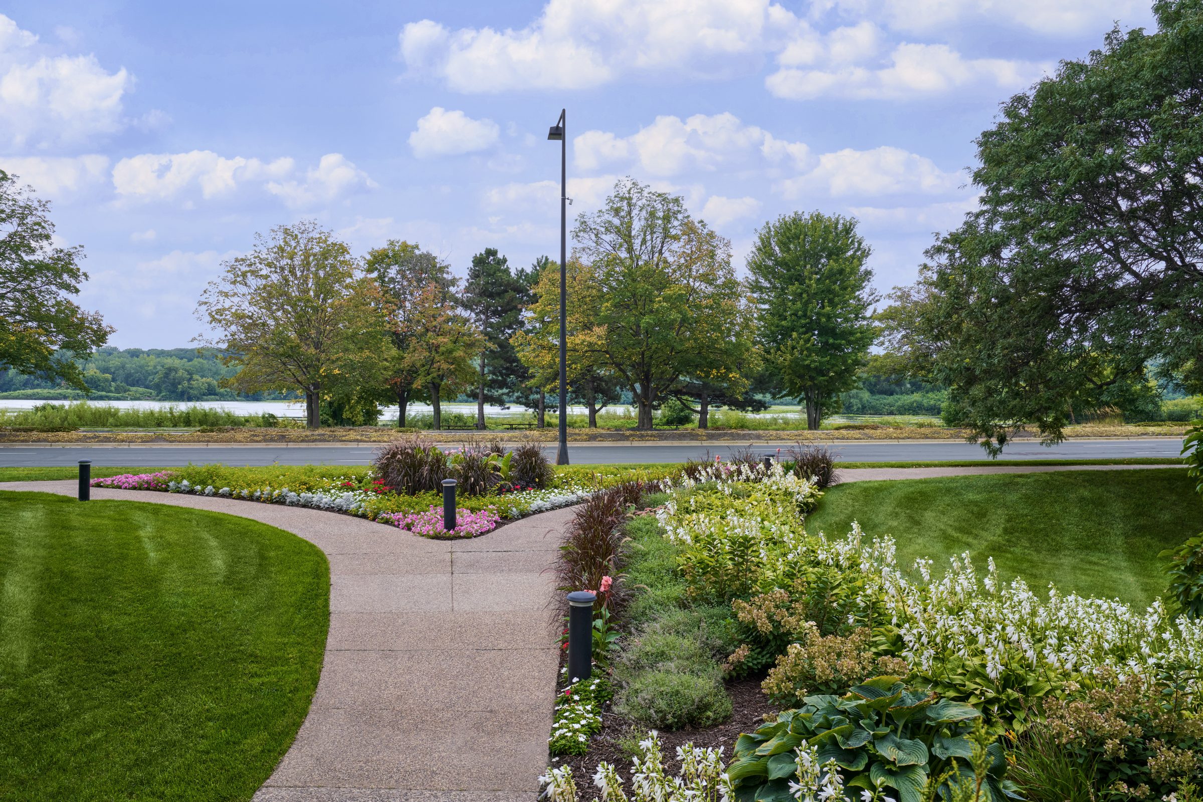 Walking path along the lake with seasonal flower beds at Normandale Lakes Office Park in Bloomington, MN
