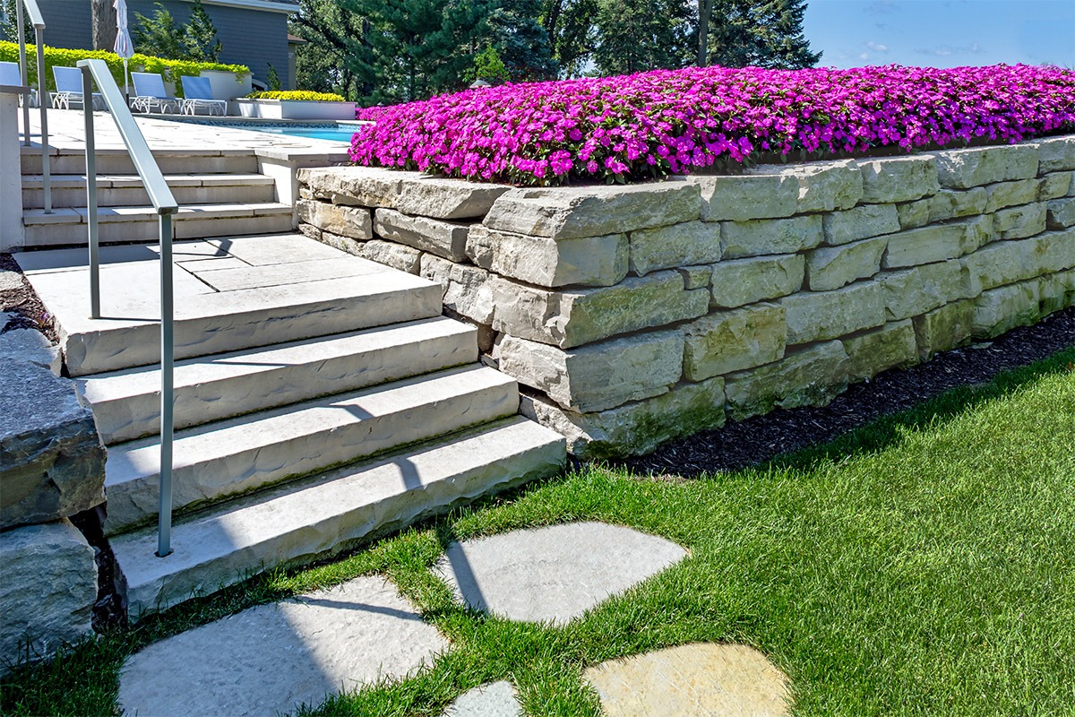 Stone steps and wall with purple flowers