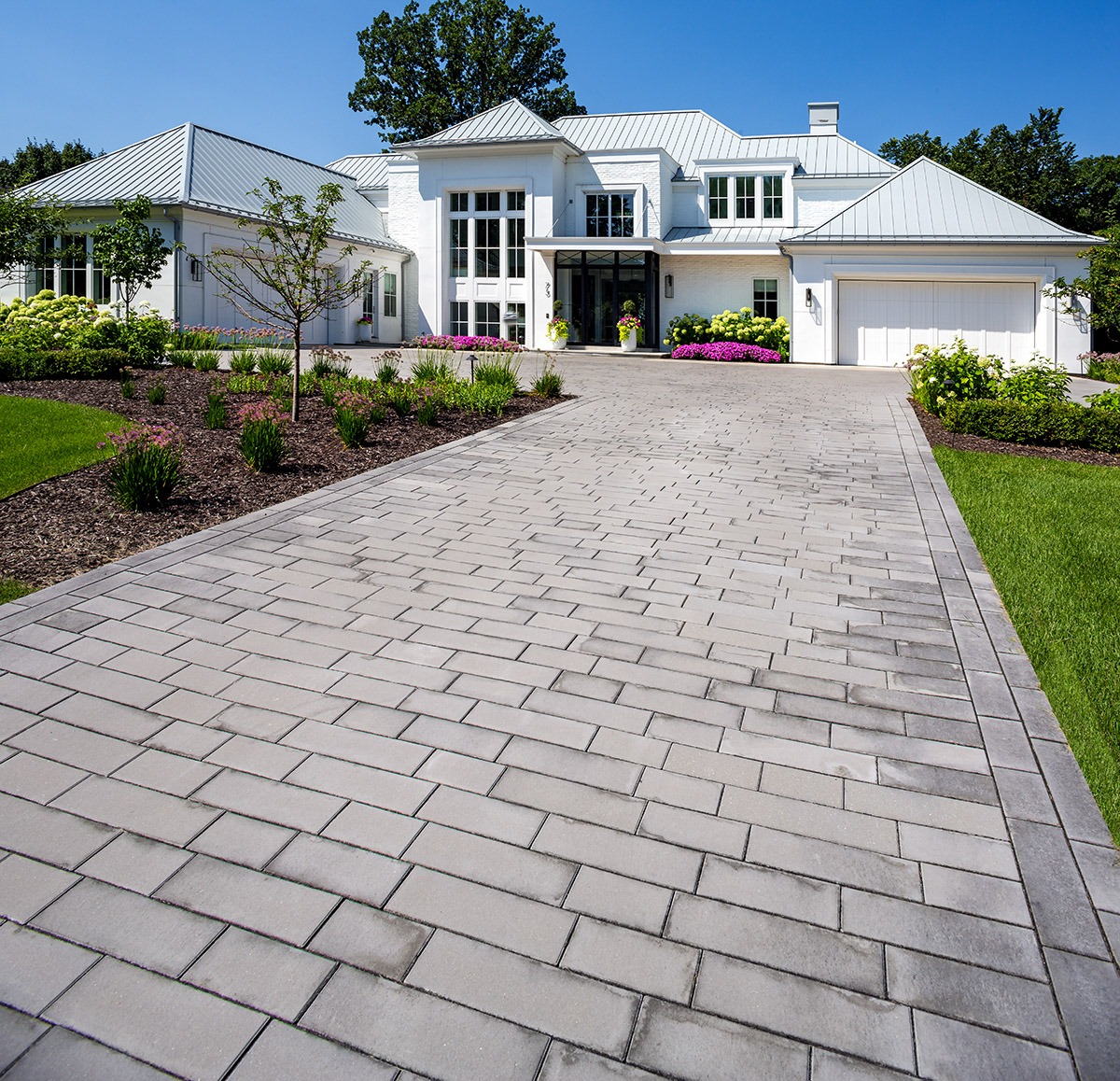 Modern house with landscaped garden and paved driveway.