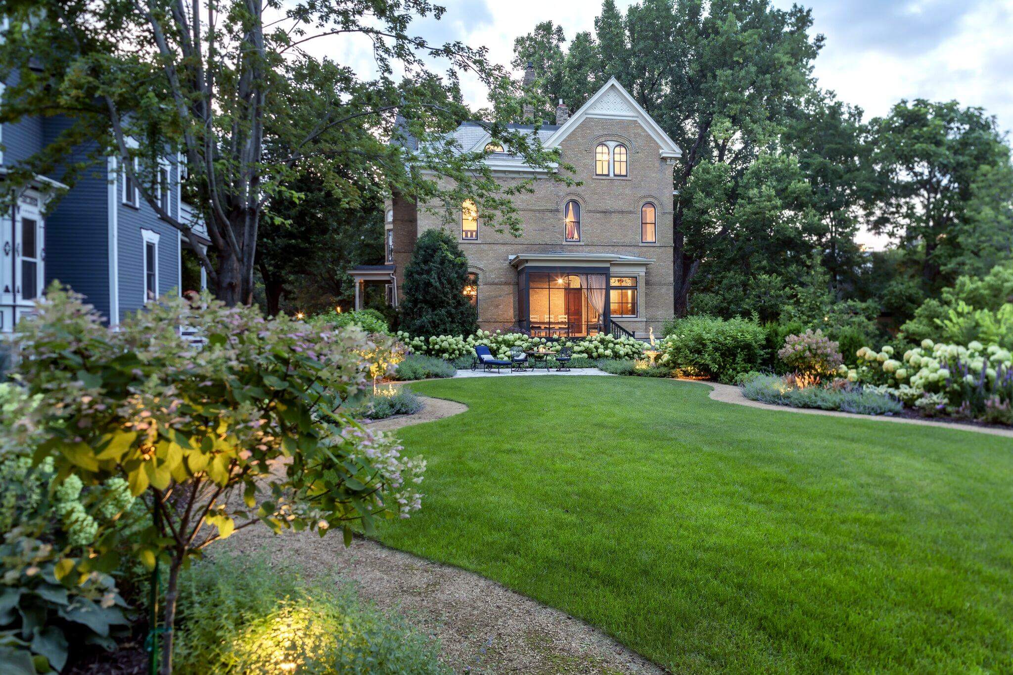 Custom residential landscape design by Southview Design featuring manicured turf, gravel pathways, and garden lighting.