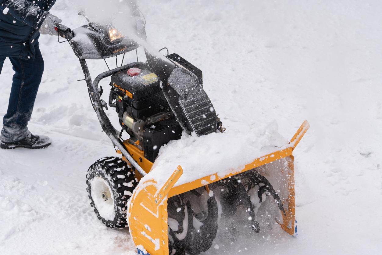 Winter snow removal service provider clearing heavy snow from a driveway.